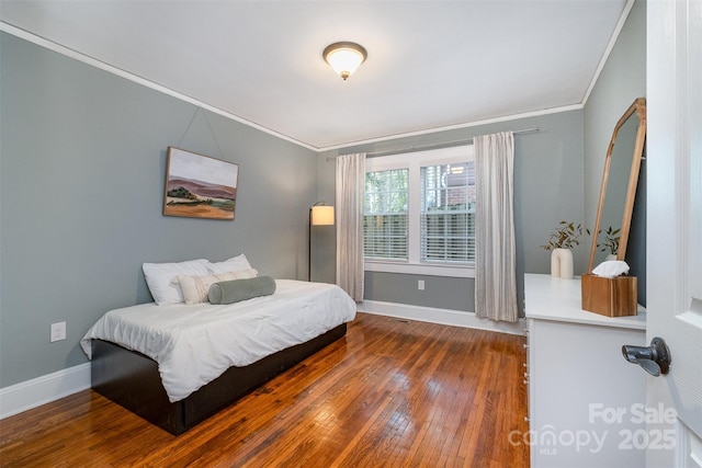 bedroom featuring hardwood / wood-style floors, ornamental molding, and baseboards