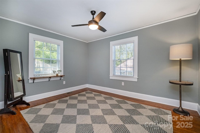 empty room featuring baseboards, ornamental molding, and a ceiling fan