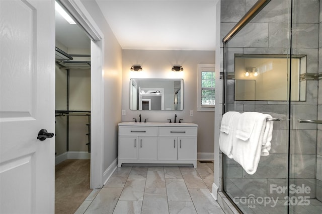 bathroom featuring double vanity, a sink, and a stall shower