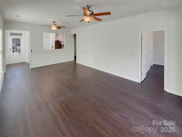 unfurnished living room with baseboards, visible vents, dark wood-type flooring, and a ceiling fan