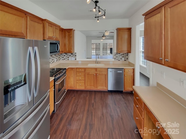 kitchen featuring light countertops, a sink, dark wood-style floors, ceiling fan, and appliances with stainless steel finishes