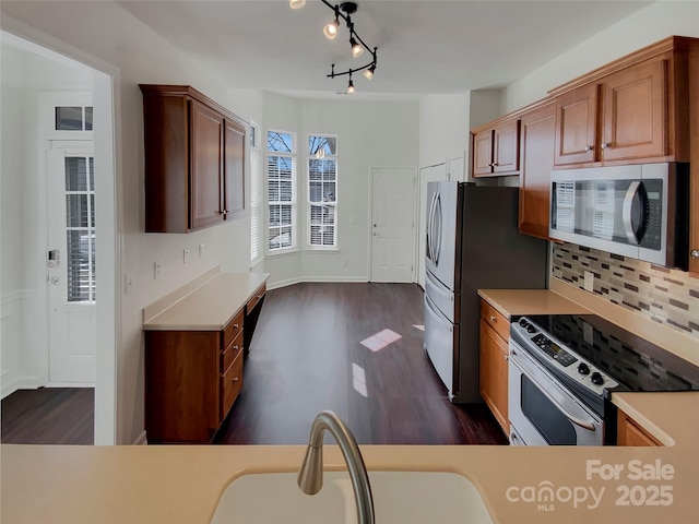 kitchen featuring a sink, backsplash, light countertops, and appliances with stainless steel finishes