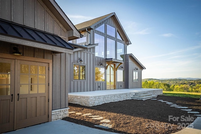 exterior space with a standing seam roof, board and batten siding, and metal roof