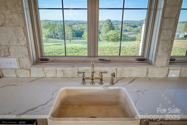 interior details with light stone counters, tasteful backsplash, and a sink