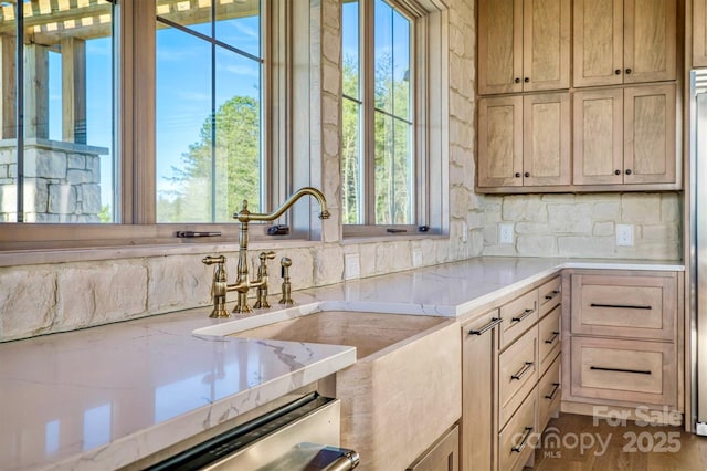 kitchen featuring light stone counters, tasteful backsplash, and plenty of natural light