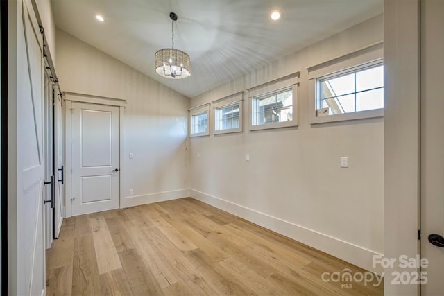 empty room featuring recessed lighting, an inviting chandelier, vaulted ceiling, light wood-style flooring, and baseboards