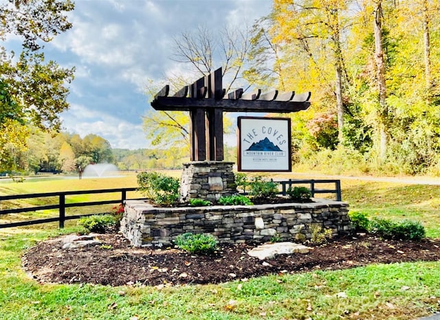 community / neighborhood sign featuring fence