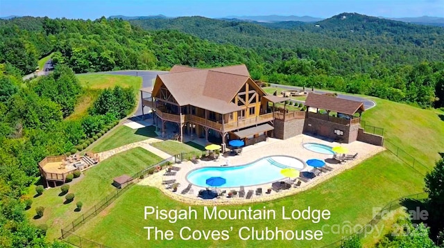drone / aerial view with a wooded view and a mountain view