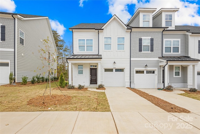 townhome / multi-family property with driveway, a standing seam roof, board and batten siding, metal roof, and a garage