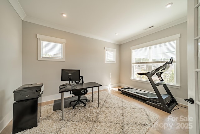 office space with baseboards, visible vents, crown molding, and wood finished floors