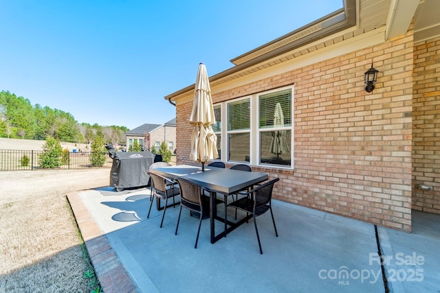 view of patio with outdoor dining area and fence