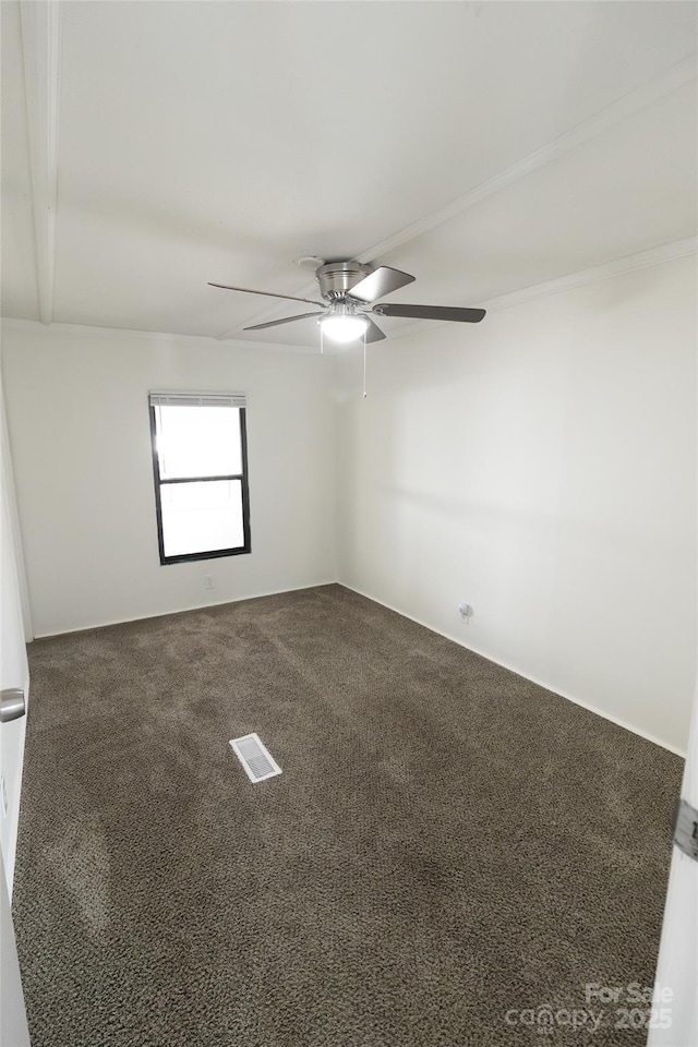 carpeted spare room featuring visible vents and a ceiling fan