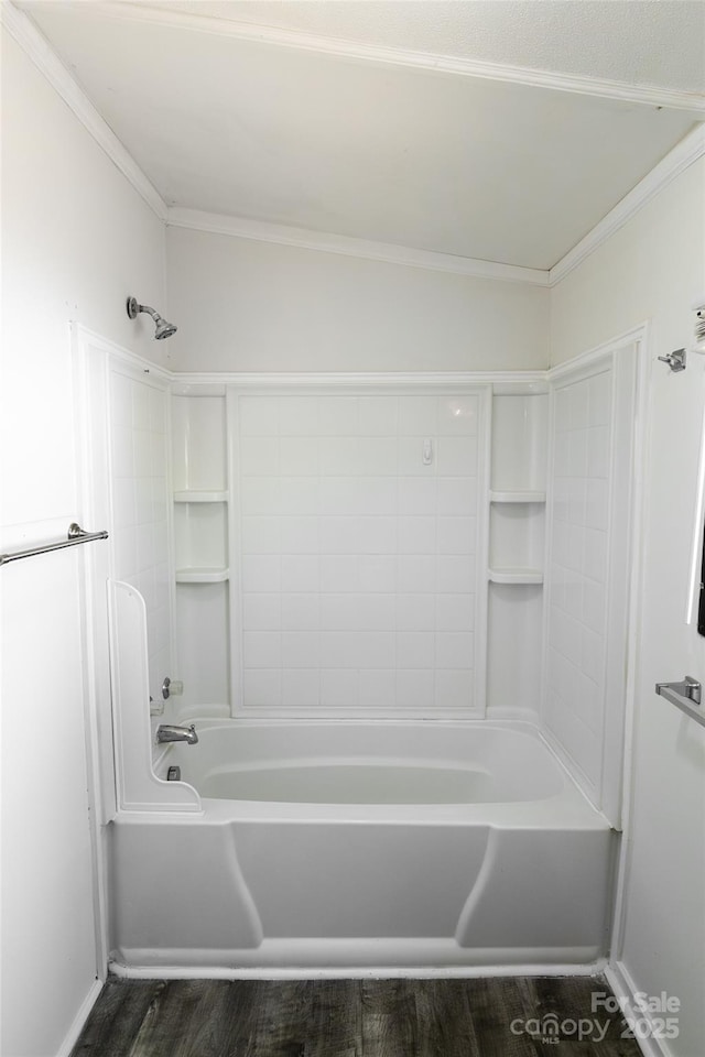 bathroom with tub / shower combination, wood finished floors, and ornamental molding