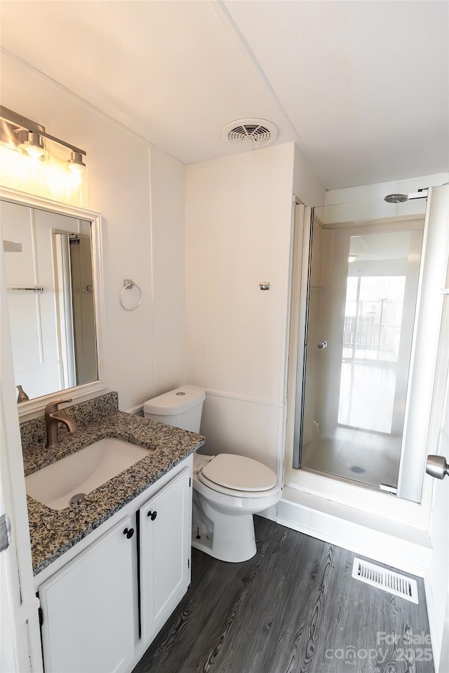 full bath with vanity, visible vents, a shower stall, and wood finished floors