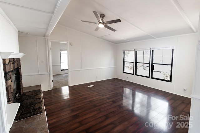 unfurnished living room with lofted ceiling, wood finished floors, a decorative wall, and a ceiling fan