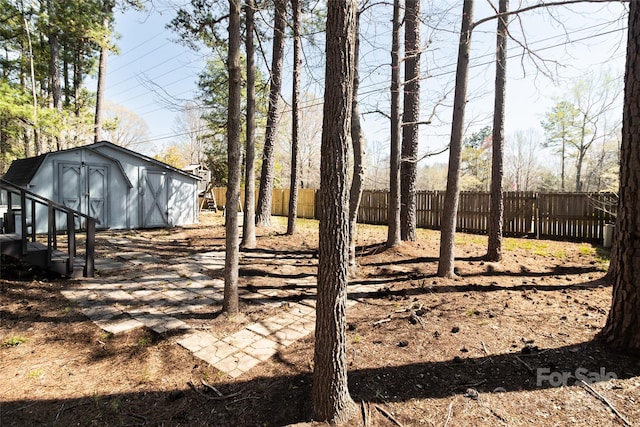 view of yard featuring a storage unit, an outdoor structure, and fence
