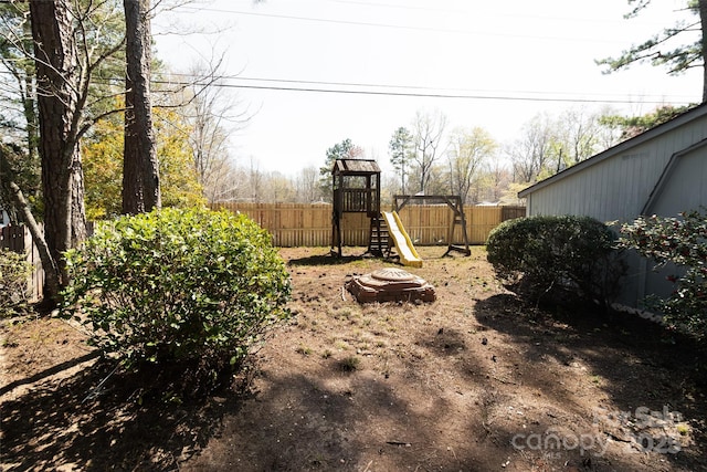 view of yard with a fenced backyard and a playground