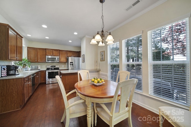 dining room with visible vents, an inviting chandelier, crown molding, and dark wood-style floors