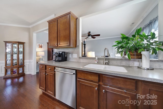kitchen featuring crown molding, stainless steel dishwasher, dark wood finished floors, a ceiling fan, and a sink
