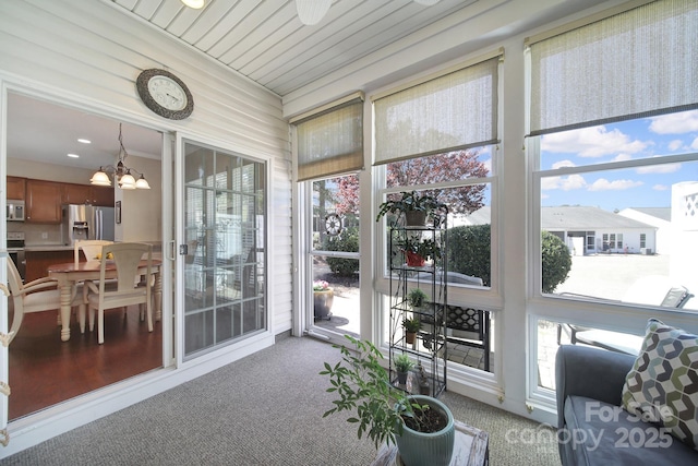 sunroom / solarium with an inviting chandelier