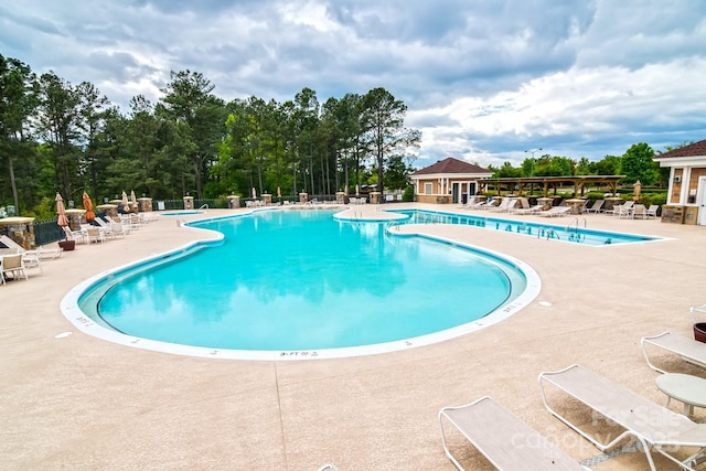 pool with a patio area and fence