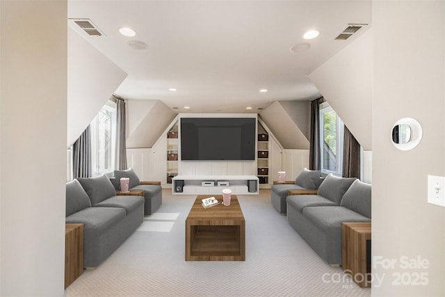 living area featuring light carpet, recessed lighting, visible vents, and a decorative wall