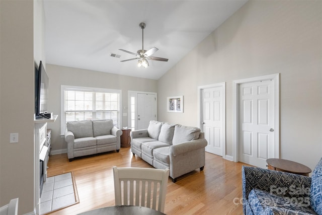 2783 Clover Rd NW, Concord, NC 28027 - living room with light wood-type flooring, ceiling fan, high vaulted ceiling, and a tile fireplace