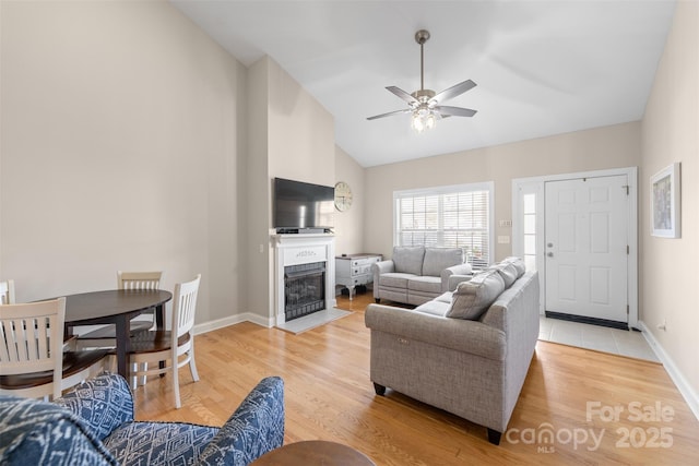 2783 Clover Rd NW, Concord, NC 28027 - living area featuring light wood-style flooring, a ceiling fan, a fireplace with flush hearth, and high vaulted ceiling