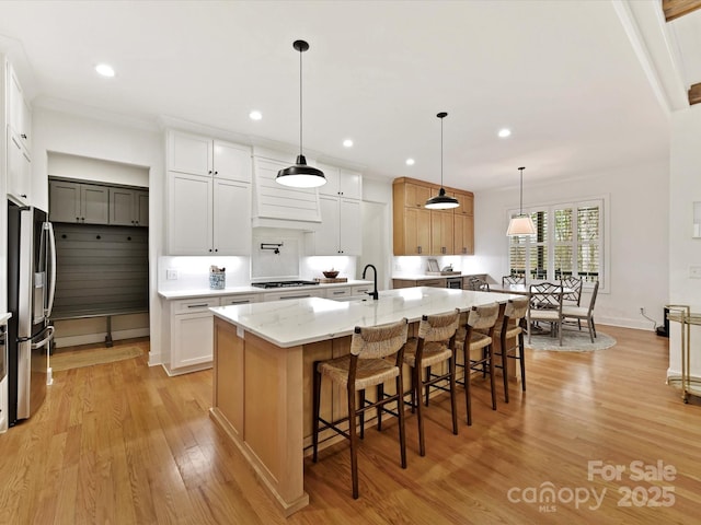 911 Abilene Ln, Fort Mill, SC 29715 - kitchen with stainless steel appliances, light wood finished floors, a kitchen breakfast bar, light stone counters, and a large island with sink