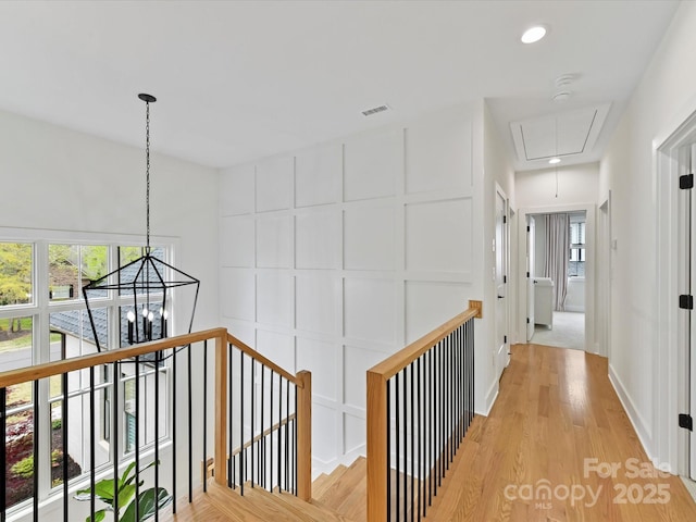 911 Abilene Ln, Fort Mill, SC 29715 - hall with an upstairs landing, attic access, light wood finished floors, a chandelier, and a decorative wall