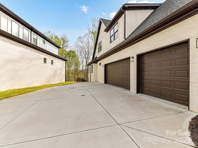 911 Abilene Ln, Fort Mill, SC 29715 - view of side of property with board and batten siding, a garage, concrete driveway, and a shingled roof