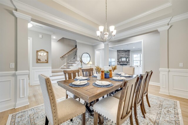6207 Majesty Ct, Fort Mill, SC 29707 - dining area featuring decorative columns, a wainscoted wall, a tray ceiling, and light wood-style floors