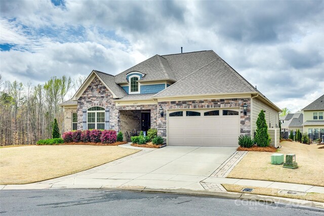 6207 Majesty Ct, Fort Mill, SC 29707 - french country inspired facade featuring stone siding, driveway, a garage, and roof with shingles