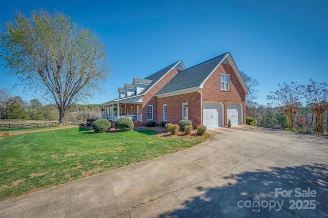 view of home's exterior featuring concrete driveway, covered porch, brick siding, a garage, and a yard