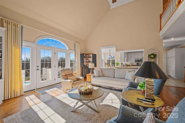 living area featuring french doors, high vaulted ceiling, and wood finished floors
