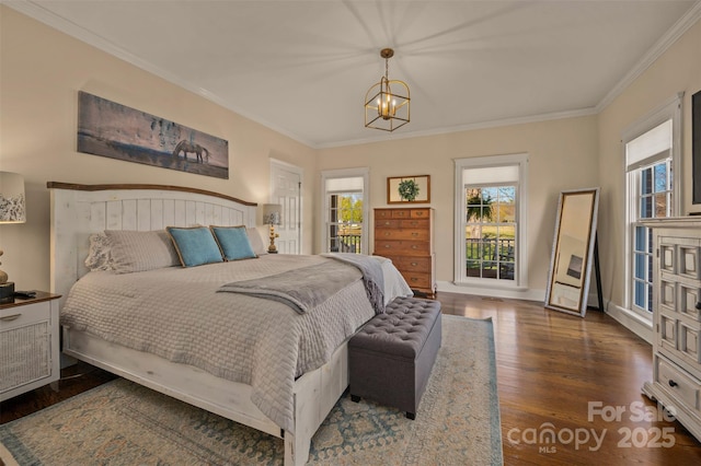 bedroom featuring baseboards, ornamental molding, wood finished floors, and a notable chandelier