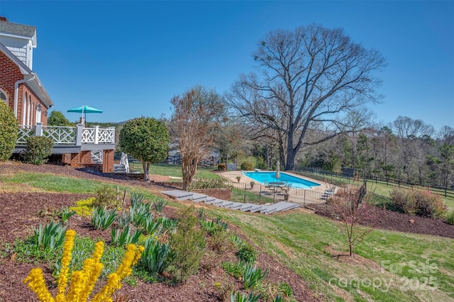 view of yard with stairs, a wooden deck, fence, and a fenced in pool