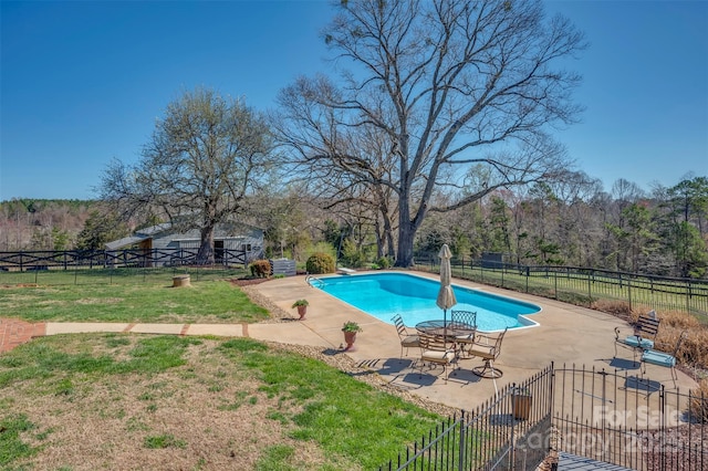 view of swimming pool with fence, a fenced in pool, a patio, and a yard