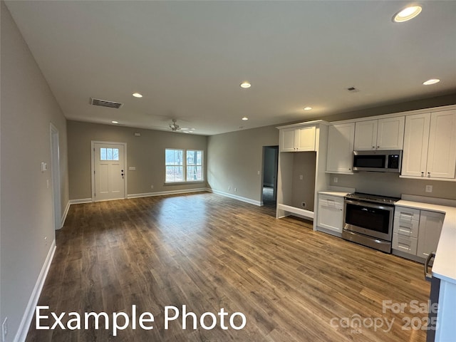 318 Stanback St, Mount Gilead, NC 27306 - kitchen with stainless steel appliances, light countertops, recessed lighting, wood finished floors, and white cabinetry