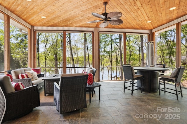 sunroom featuring an outdoor living space, wooden ceiling, outdoor dining area, and a wall of windows