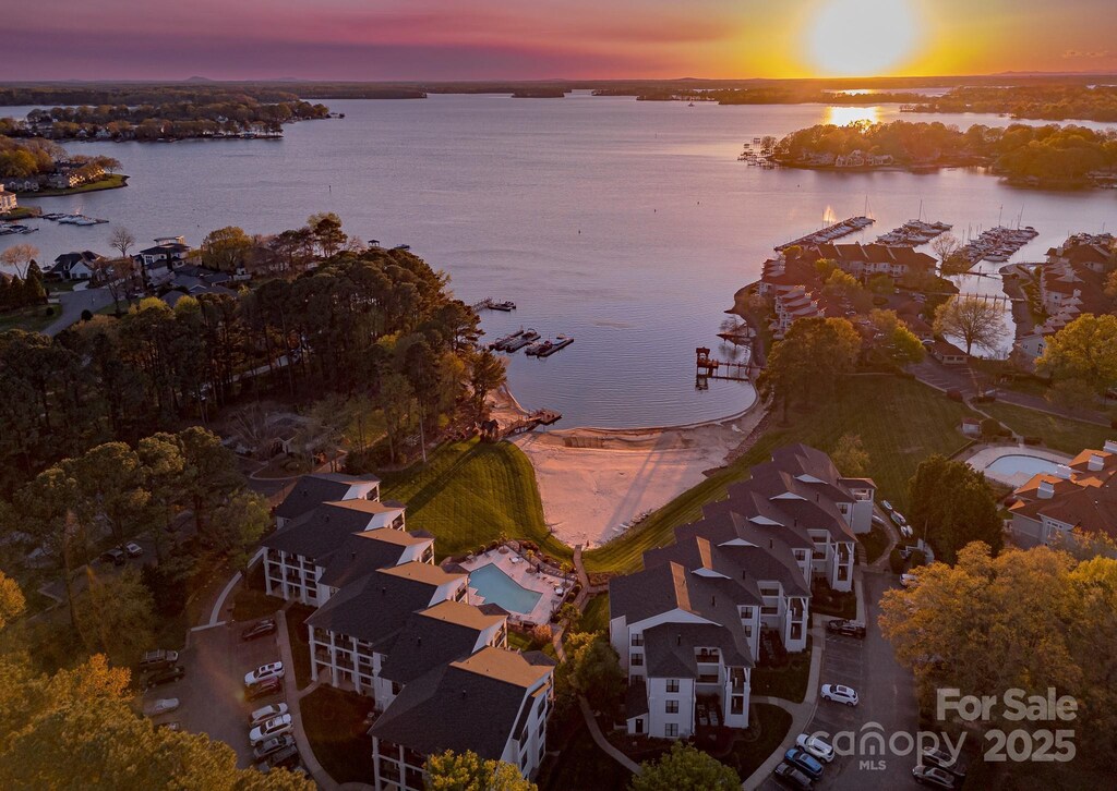 aerial view at dusk featuring a water view