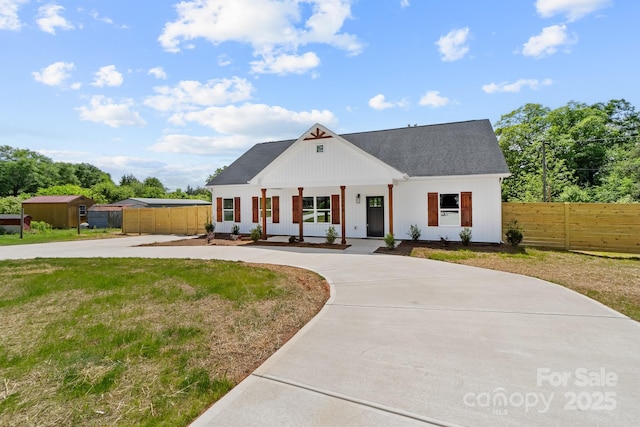 modern inspired farmhouse with curved driveway, roof with shingles, and fence