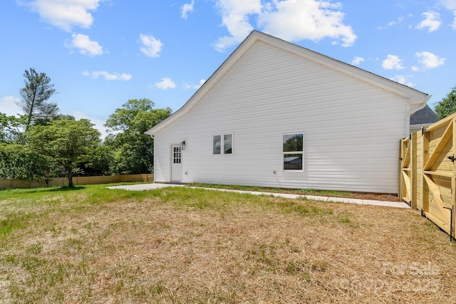 back of house featuring a lawn and a fenced backyard