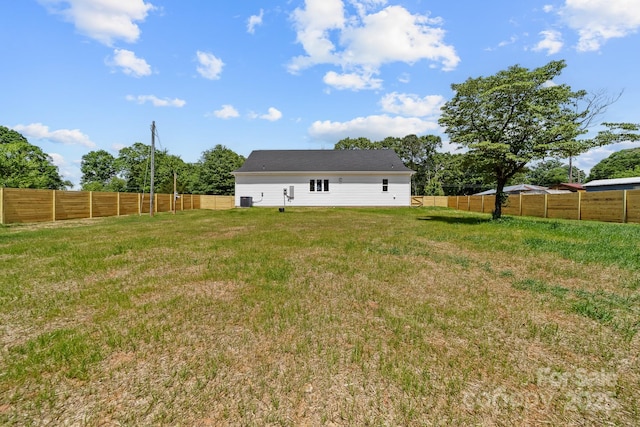 rear view of house featuring a fenced backyard