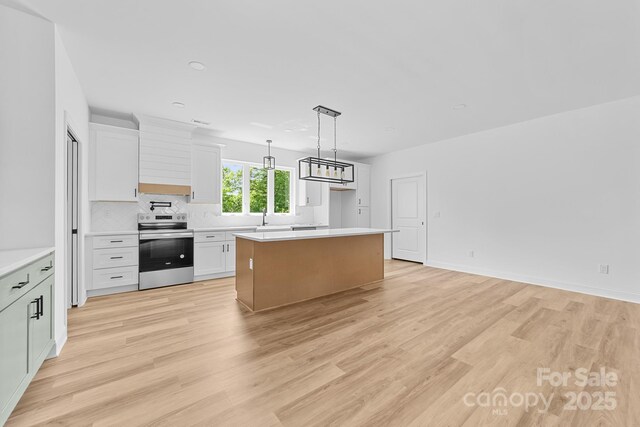 kitchen featuring a kitchen island, white cabinetry, light wood-style flooring, and electric stove