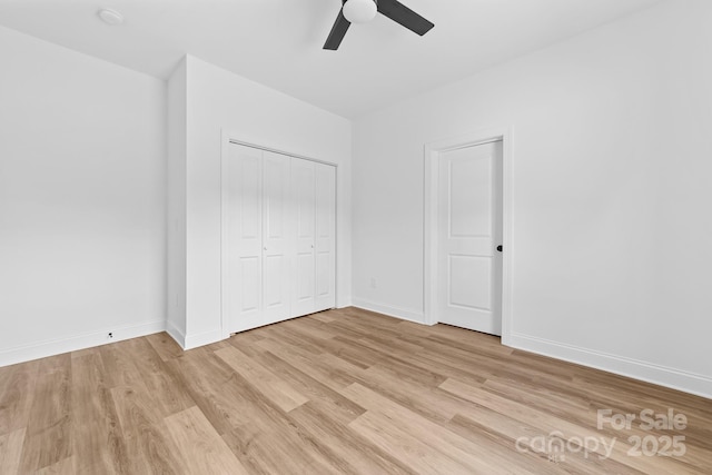 unfurnished bedroom featuring baseboards, ceiling fan, light wood-style flooring, and a closet