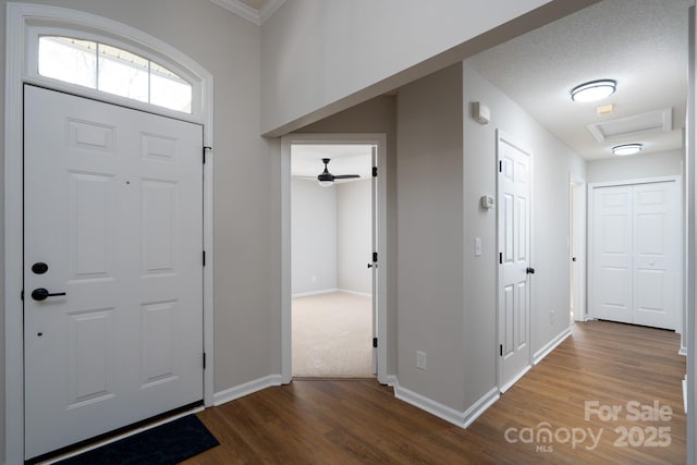 foyer featuring baseboards, wood finished floors, and a ceiling fan