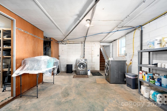 below grade area featuring concrete block wall and independent washer and dryer
