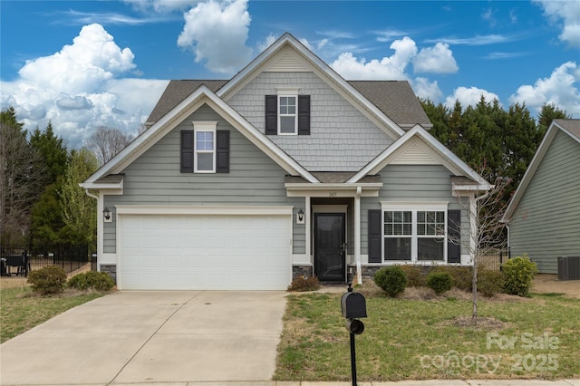 craftsman-style house featuring stone siding, a garage, a front lawn, driveway, and a shingled roof