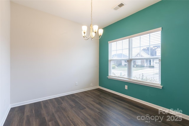 empty room with baseboards, visible vents, a notable chandelier, and dark wood-style flooring